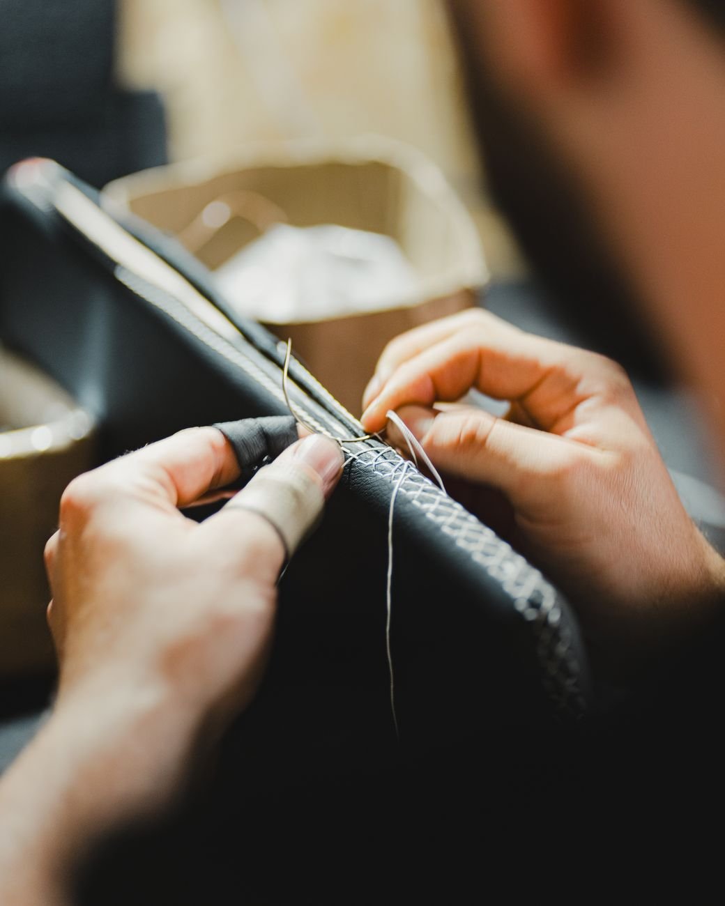 Close-up of skilled artisan hand-stitching, showcasing fine craftsmanship